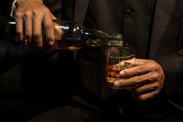 Closeup businessmen holding a glass of whiskey