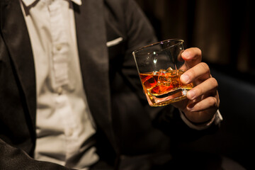 Closeup businessmen holding a glass of whiskey