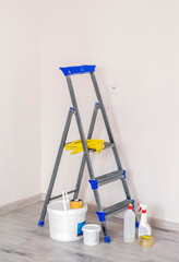 construction ladder on the background of a light wall and building materials for repair