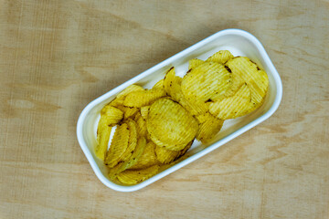 Salted Potato Wafers in White Square Bowl on Wooden Table, Heap of Wafers, Copy Space, Heap of Chips, Top View