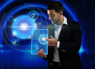 Business, Technology, Internet and network concept. Young businessman working on a virtual screen of the future and sees the inscription: 2022 goals