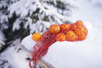 Tangerines in a bag are hanging on an old door.