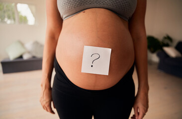 Torso of Caucasian pregnant female standing upright with question mark on belly. Gender reveal, modern lifestyle