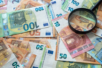 concept of inflation in Europe, euro money with  magnifying glass