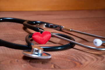 Red heart and stethoscope or phonendoscope on the background of natural wood: cardiologists' Day,...