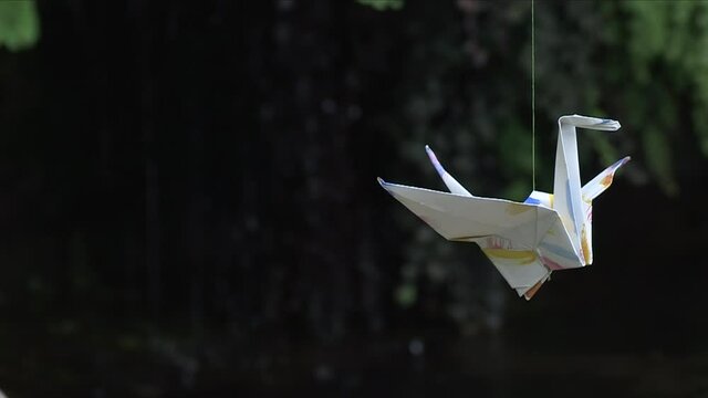 close up of Origami hanging in line. Paper crane bird, traditional japanese handcraft. Orizuru