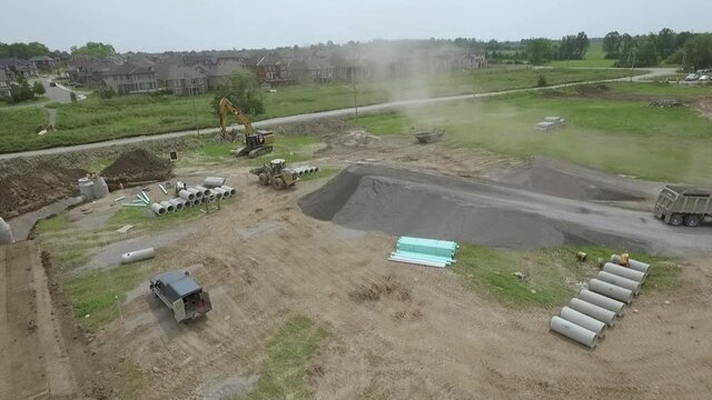 Aerial Of Dump Truck Backing Up A Gravel Ramp To Unload Gravel.