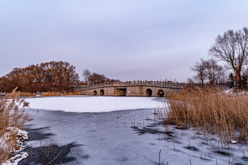 Obraz premium Winter scenery of the North Lake National Wetland Park in Changchun, China under the sunset