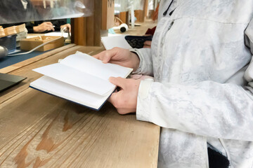 御朱印を押してもらうために並ぶ女性