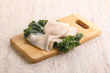 Raw squid over wooden board