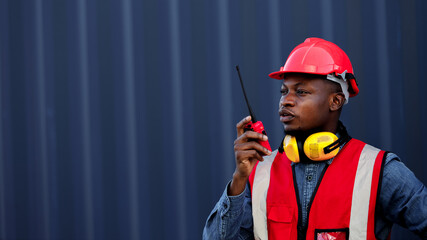 African worker is using walkie talkie in a container yard.