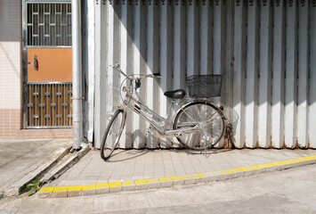 Horizontal traditional retro Hong Kong style silver shop rolling door with old vintage bicycle