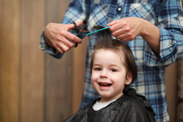 A little boy is trimmed in the hairdresser's bright emotions on face