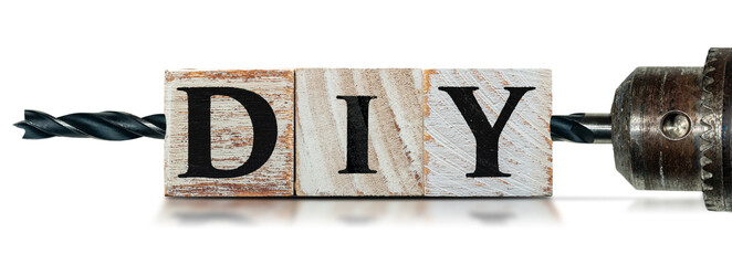 Close-up of DIY text (do it yourself), made of wooden blocks and an electric drill with black tip,...
