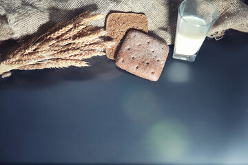 Fresh loaves of bread with wheat and gluten on a black table. Bakery and grocery concept. Fresh,...