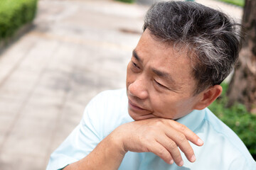 old man sweating due to hot weather, heatstroke, strong uv light or sunburn