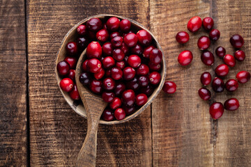 Red cranberries on wooden background. Brries in a bowl.