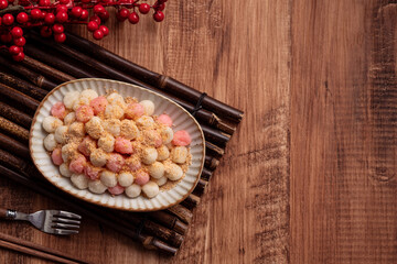 Deep-fried red and white tangyuan with peanut powder.