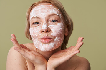 Blonde girl with face mask posing with pleasure emotion and hands near her face