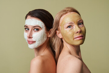 Women with facial masks after taking shower looking at the camera isolated