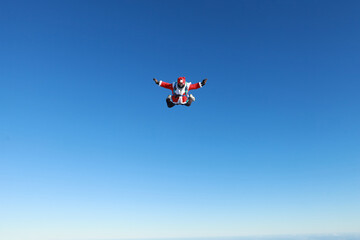 Fototapeta na wymiar Skydiving. Skydiver dressed as Santa Claus flies in the sky.