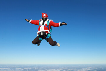 Fototapeta na wymiar Skydiving. The jump before New Year. Skydiver dressed as Santa Claus.