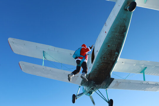 Skydiving. Santa Claus is flying near an airplane.