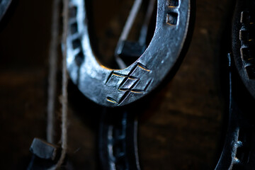 Close-up of blacksmith decorative elements horseshoe at forge, workshop. Handmade, craftsmanship and blacksmithing concept