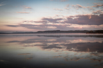 misty morning sunrise by the lake with a perfect reflection