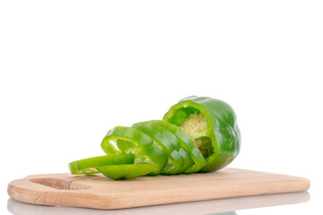 One juicy sweet green pepper cut into slices on a wooden board, close-up, isolated on white.