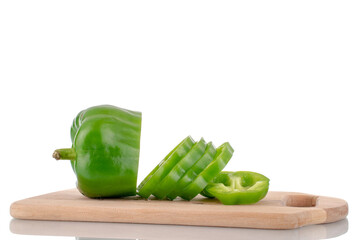 One juicy sweet green pepper cut into slices on a wooden board, close-up, isolated on white.