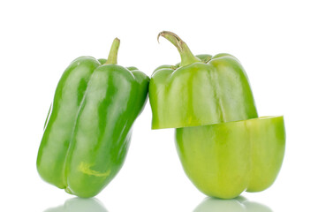 Two organic sweet green peppers, one cut in half, close-up, isolated on white.