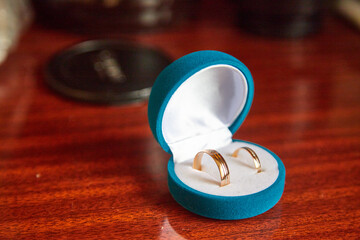 Two gold rings in box near beautiful flowers