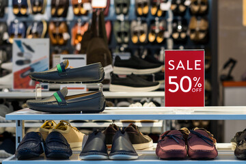 sale 50% off mock up advertise display frame setting over the men shoes shelf in the shopping department store for shopping, business fashion and advertisement concept