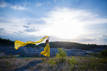 Summer lifestyle of stunning happy woman running in nature. In a long yellow dress. Romantic mood....