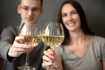 a young couple tasting white wine,close up of hands holding glass
