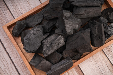 Natural wood charcoal on wooden background, Black charcoal on wooden tray. 