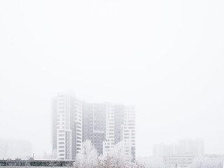 Silhouette of an unknown building in an icy fog on a winter day.