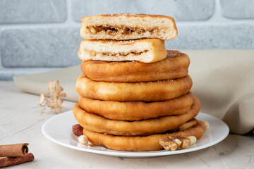 Korean street food hotteok made from sweet dough stuffed with various nuts, sugar and cinnamon. Close-up.