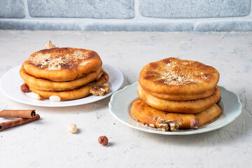 Traditional dessert from South Korea. Yeast dough stuffed with sugar, cinnamon and nuts on two plates, white table.