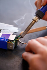 A foreman repairs an electrical appliance in his repair office.