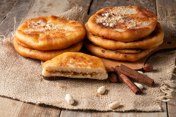 Traditional South Korean dessert hotteok stuffed with nuts and sugar. Wooden table.