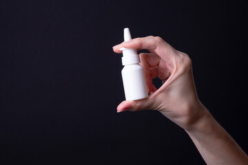 female hand holding nose spray