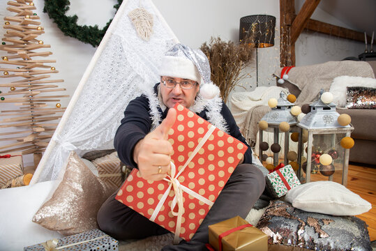 Family grandfather mature man wearing silver santa claus hat holding christmas gift boxes and show thumb up