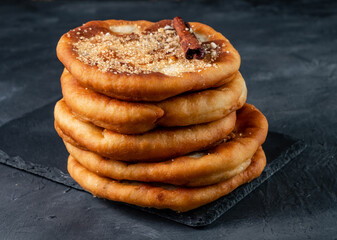A stack of korean hotteok dessert with nuts and cinnamon brown sugar. Dark table.