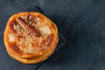 Hotteok fried dough stuffed with nuts, sugar and cinnamon. Korean street food. View from above. Dark background. Free space.