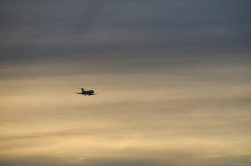 airplane in the evening sky in luminous horizon.