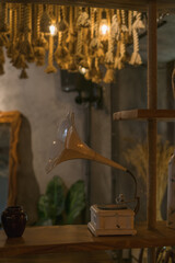 Old music player in a coffee shop. Retro style design Chandeliers made from the rope. Antique items on the wall. Solid wood furniture. Coffee shop