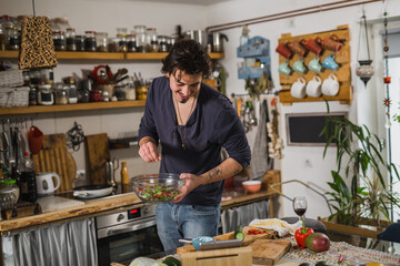 man preparing salad meal in his kitchen