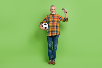 Full body photo of hooray aged beard man watch football wear shirt jeans sneakers isolated on green background